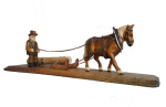 Pferd zieht Baum mit Waldarbeiter